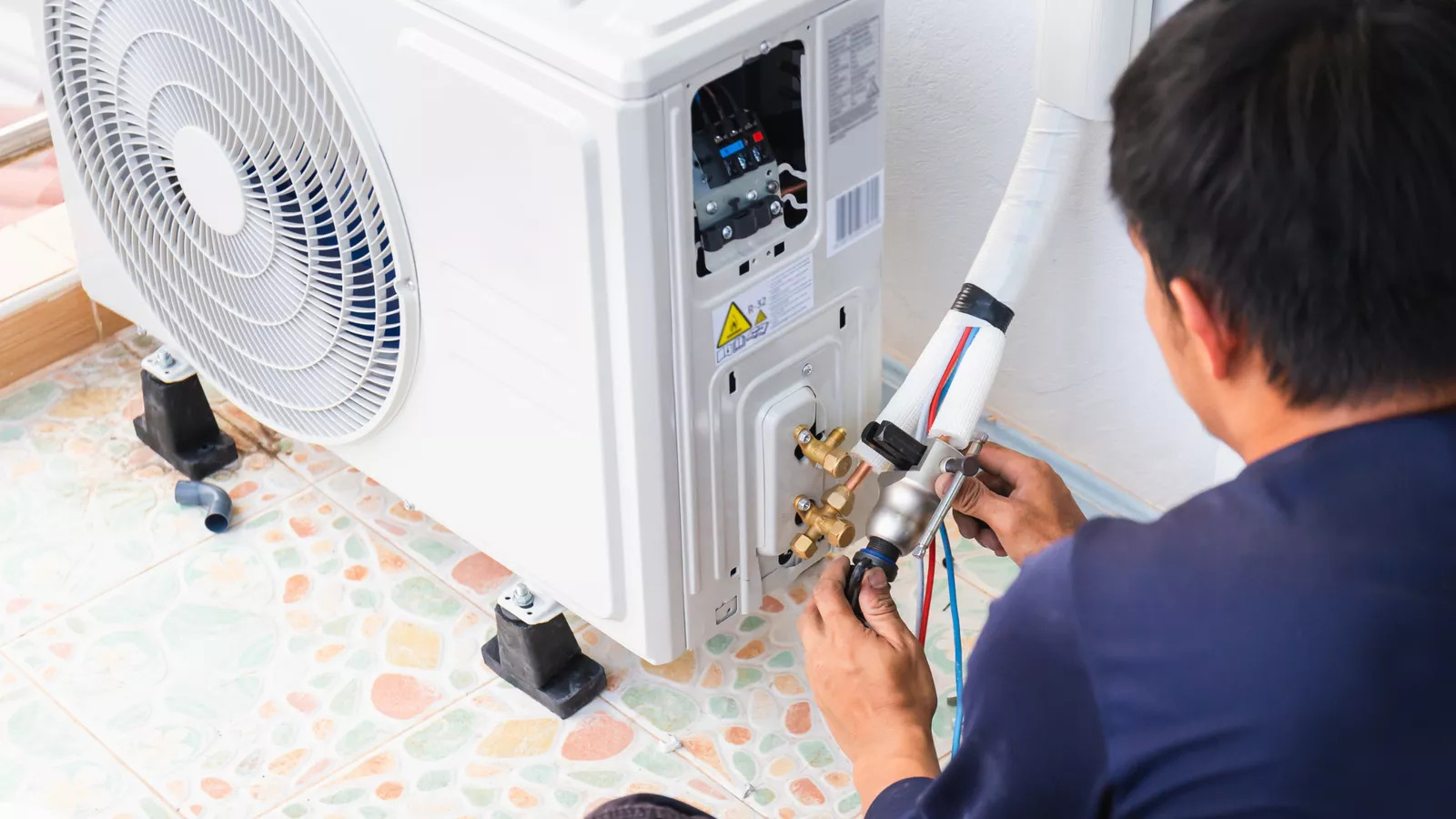 Technician servicing commercial HVAC equipment designed for easy maintenance